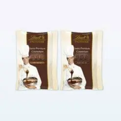 Le chef présente les paquets de 500 g de chocolat de couverture Lindt Patisserie Premium avec une cuillère.