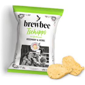 Brewbee Tschipps bag with rosemary and herbs, shows a smiling couple with smoothies. Two chips are placed next to it.