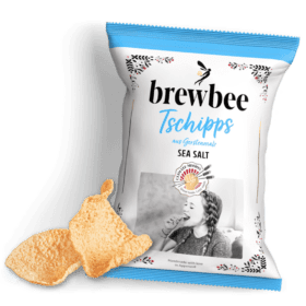 A package of Brewbee Tschipps, sea salt flavor, with two chips beside it. The bag shows a woman enjoying the chips and says "Handmade with love in Augsburg.