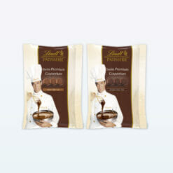Chef displaying Lindt Patisserie Premium Chocolate Couverture 500g packets with spoon.